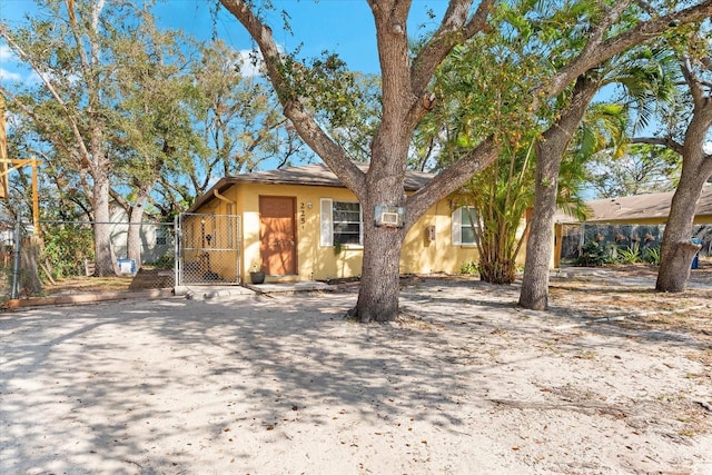 view of front facade with fence, a gate, and stucco siding