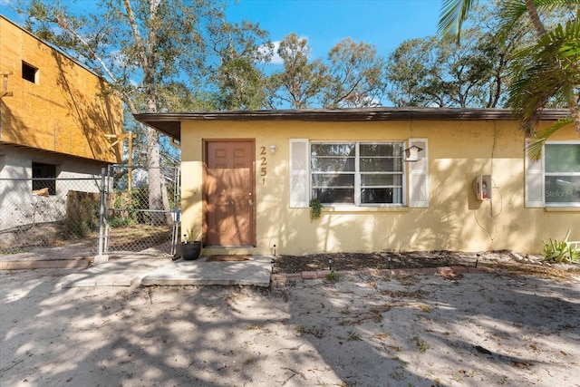 view of front of home featuring a gate, fence, and stucco siding