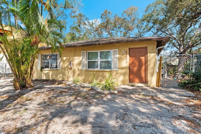 view of front of house with a gate, fence, and stucco siding