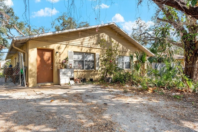 view of side of home with fence and stucco siding