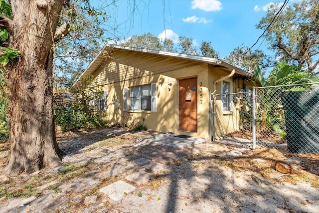 view of front of property featuring fence, a gate, and stucco siding