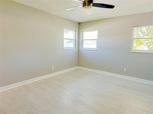 spare room with ceiling fan, a textured ceiling, and light hardwood / wood-style floors