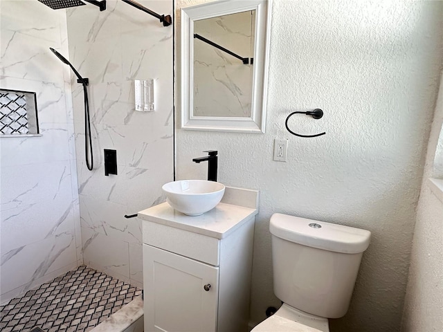 bathroom featuring vanity, tiled shower, and toilet