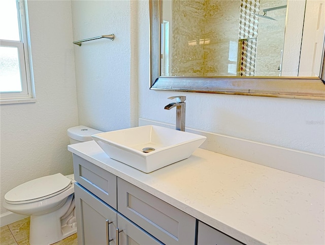 bathroom with toilet, vanity, and walk in shower