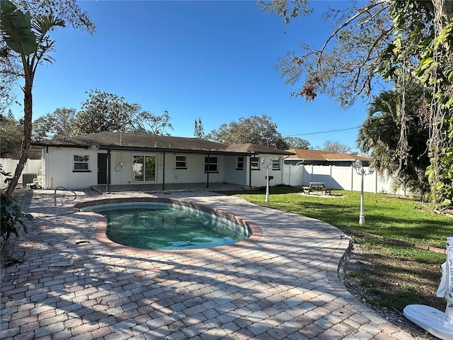 back of property with a lawn, a fenced in pool, and a patio area