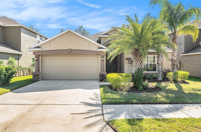 view of front of property with driveway, an attached garage, a front yard, and stucco siding