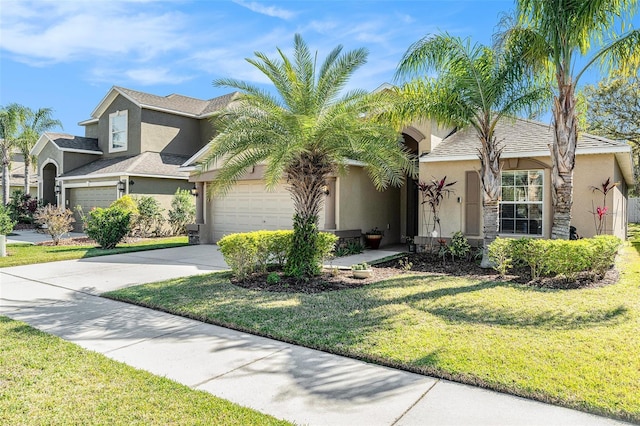 view of front of property with a front yard, concrete driveway, and stucco siding