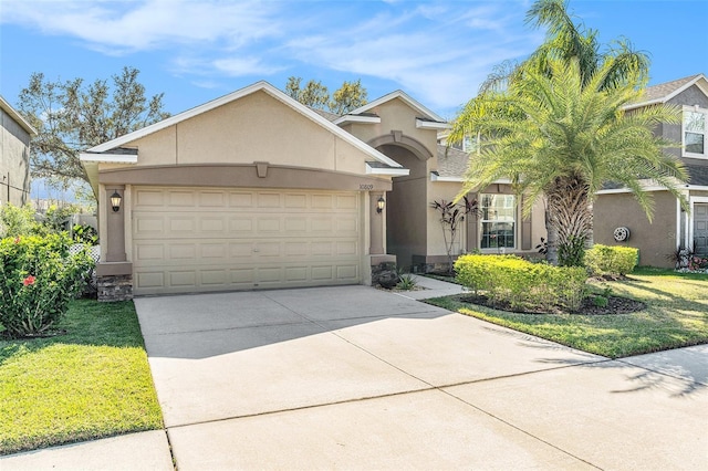 view of front facade featuring a garage, a front lawn, concrete driveway, and stucco siding