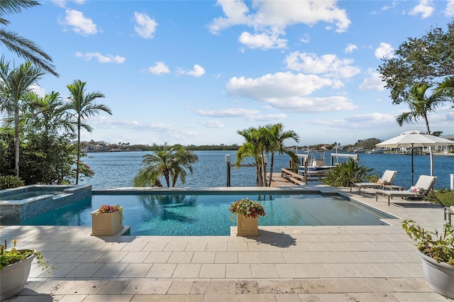 view of pool with a patio, an in ground hot tub, and a water view