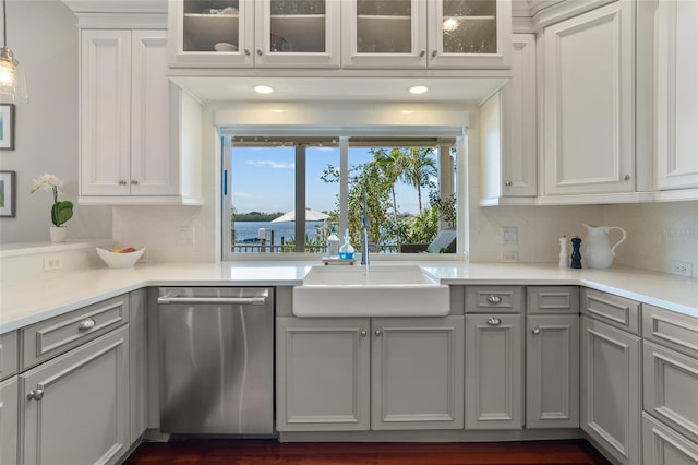 kitchen with a sink, gray cabinets, backsplash, dishwasher, and glass insert cabinets
