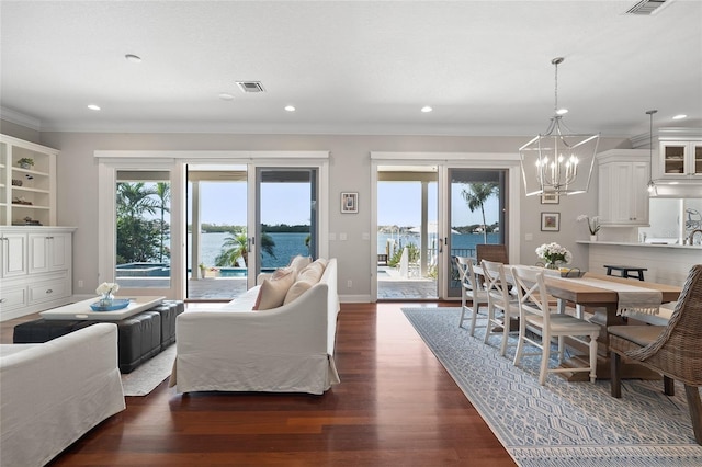 living room with recessed lighting, a notable chandelier, dark wood-style flooring, baseboards, and crown molding