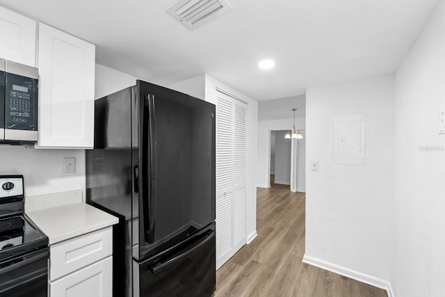 kitchen with light hardwood / wood-style flooring, white cabinetry, range with electric cooktop, and black refrigerator