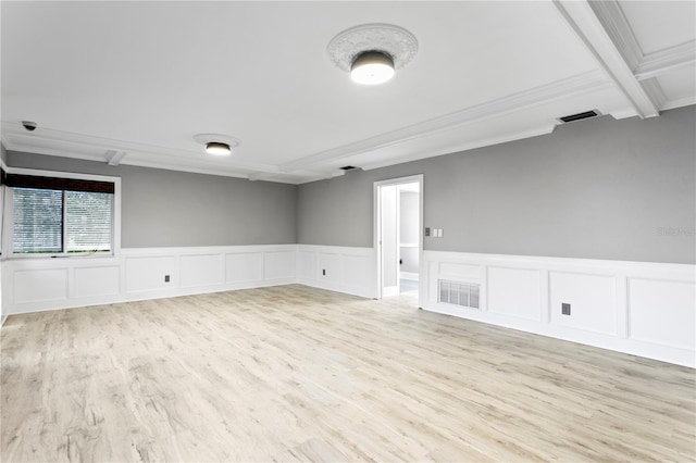 empty room featuring light hardwood / wood-style flooring, crown molding, and beam ceiling