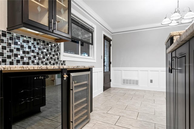 kitchen featuring a notable chandelier, tasteful backsplash, crown molding, and wine cooler