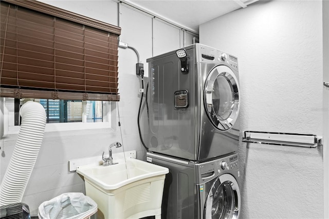 washroom with sink and stacked washer and clothes dryer