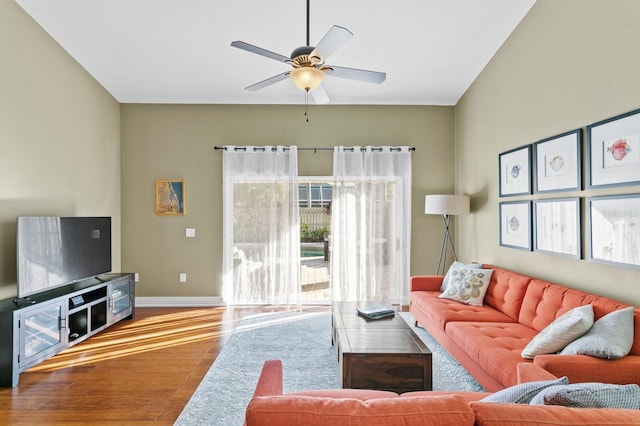 living room featuring ceiling fan, baseboards, and wood finished floors