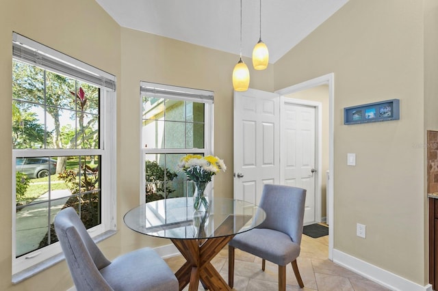 dining area with lofted ceiling, baseboards, and light tile patterned floors