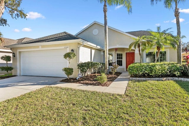 view of front of home with concrete driveway, a front yard, an attached garage, and stucco siding