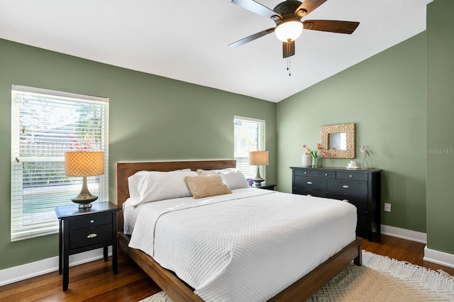 bedroom featuring vaulted ceiling, ceiling fan, dark wood-type flooring, and baseboards