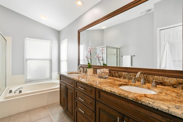 full bathroom featuring tile patterned flooring, a garden tub, a sink, vaulted ceiling, and double vanity