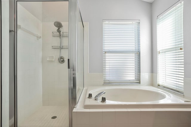 full bathroom with a wealth of natural light, a stall shower, and a bath