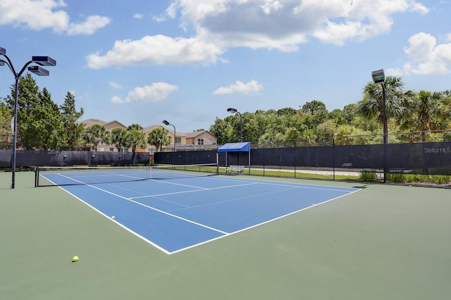 view of tennis court featuring fence