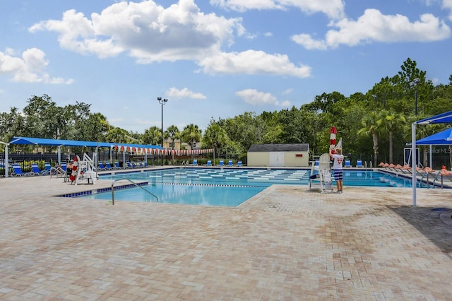 community pool with a patio area and fence