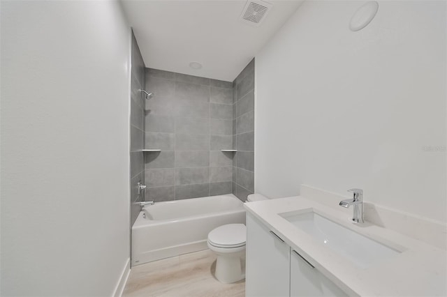 full bathroom featuring toilet, vanity, tiled shower / bath combo, and wood-type flooring