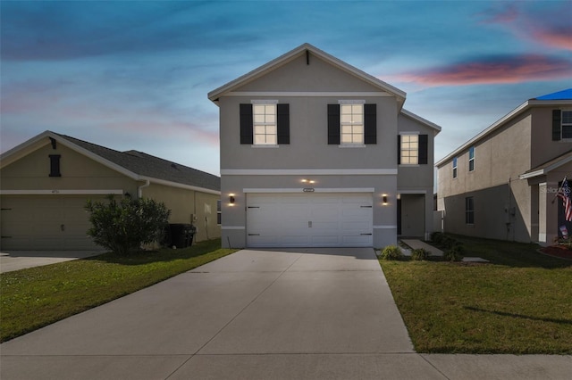 front facade featuring a garage and a yard