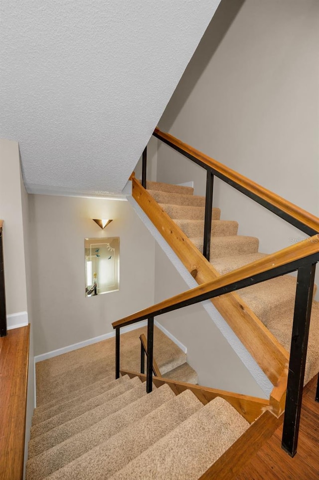 staircase featuring a textured ceiling