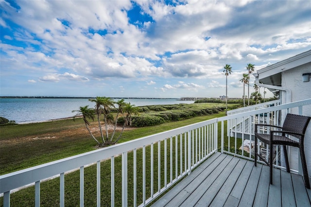 wooden deck with a lawn and a water view