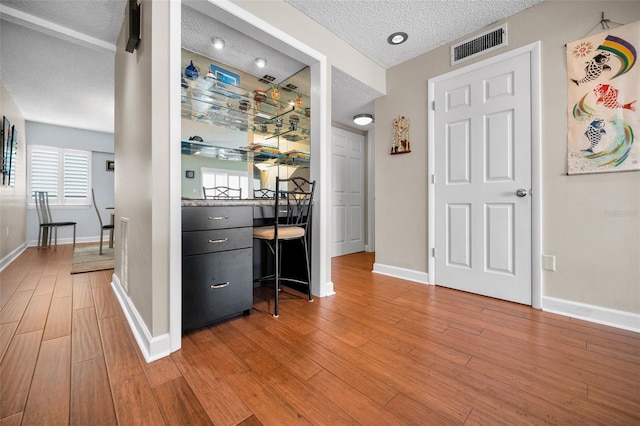 hall with wood-type flooring and a textured ceiling