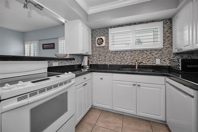 kitchen featuring sink, white appliances, white cabinets, and tasteful backsplash