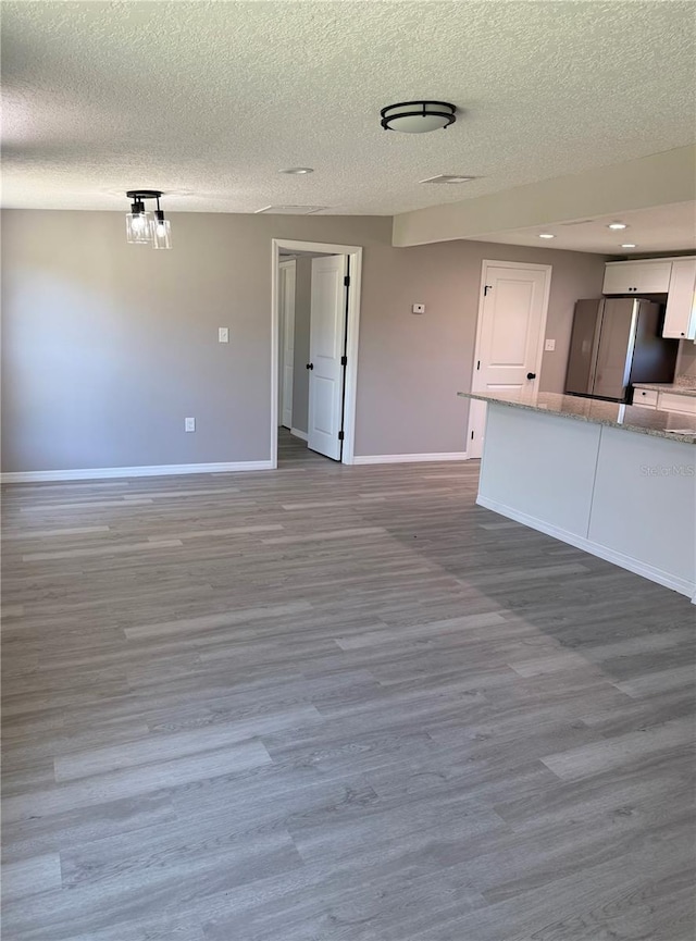 unfurnished living room with hardwood / wood-style floors and a textured ceiling