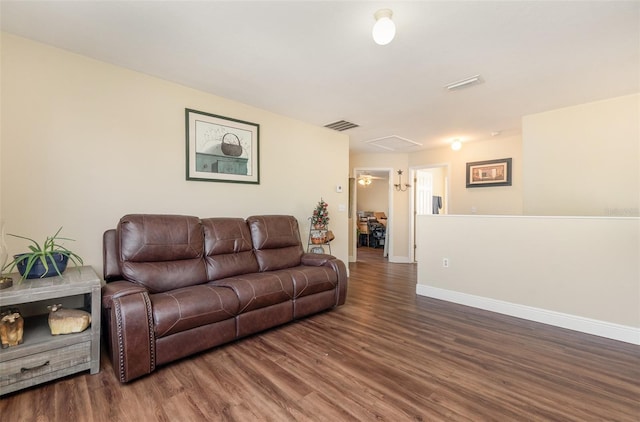 living room featuring dark wood-style floors, baseboards, and visible vents