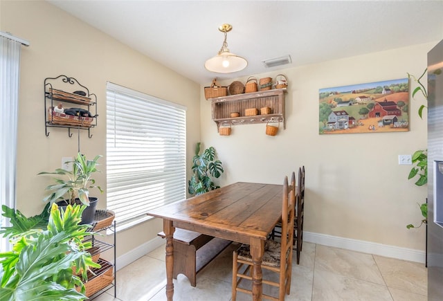 dining area with light tile patterned floors, visible vents, and baseboards