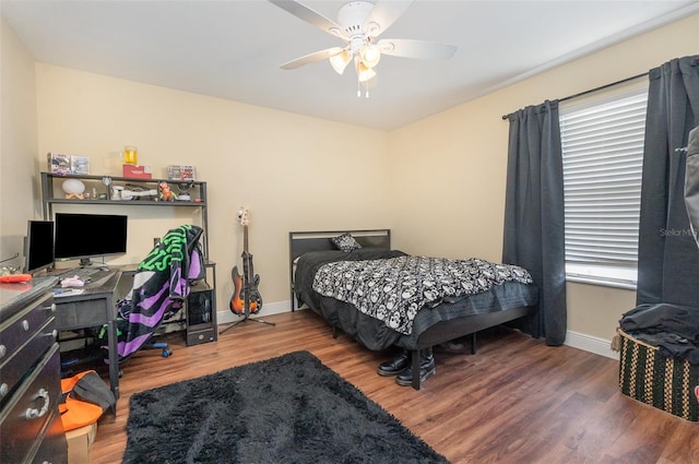 bedroom with ceiling fan, baseboards, and wood finished floors