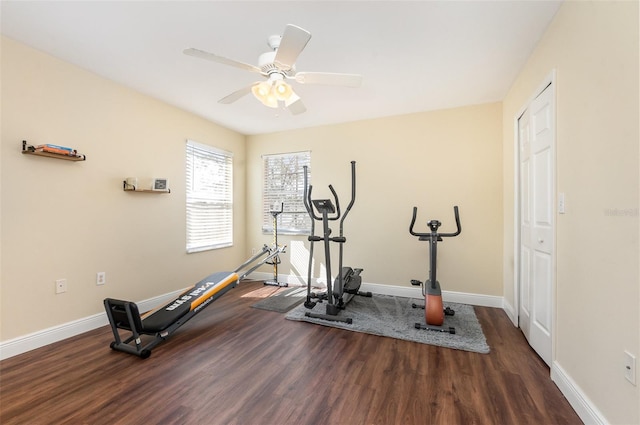 exercise area featuring baseboards, dark wood finished floors, and a ceiling fan