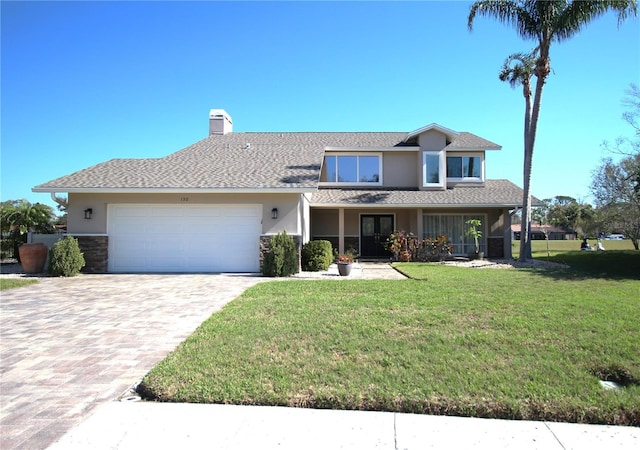 view of front of house featuring a garage, decorative driveway, stucco siding, a front lawn, and a chimney