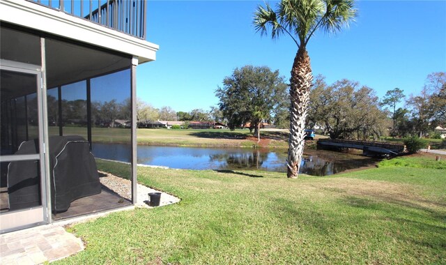 view of yard with a water view and a balcony