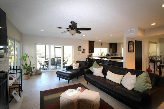 living room with a wealth of natural light, visible vents, and recessed lighting