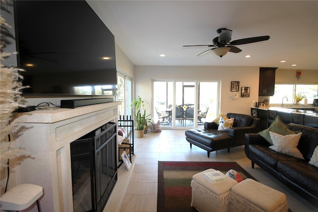 living area featuring plenty of natural light, a glass covered fireplace, and recessed lighting