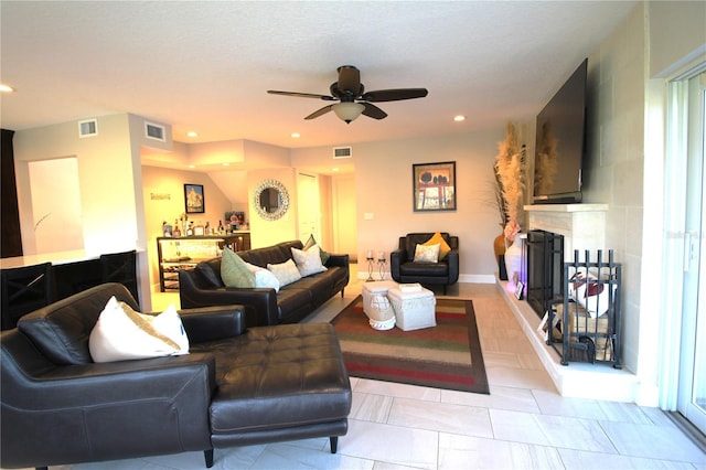 living area featuring recessed lighting, visible vents, and a fireplace with raised hearth