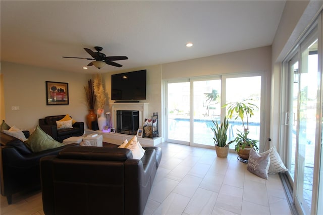 living room featuring recessed lighting, ceiling fan, and a glass covered fireplace