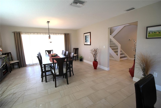 dining room featuring visible vents, baseboards, and stairs