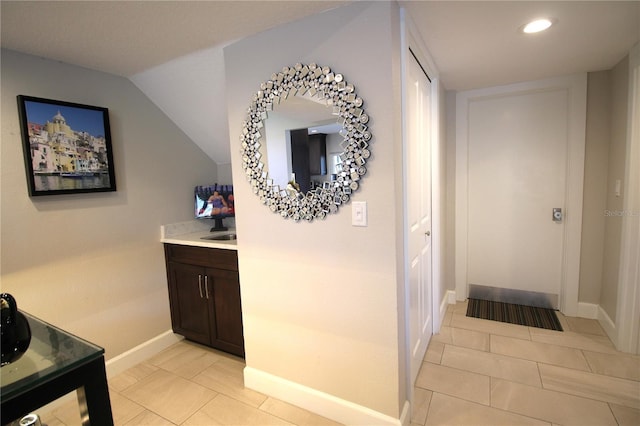 hall featuring light tile patterned floors, baseboards, and recessed lighting