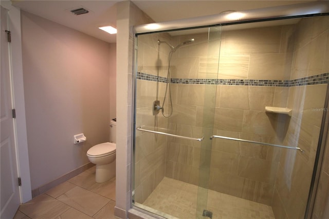 bathroom with a stall shower, baseboards, visible vents, and toilet