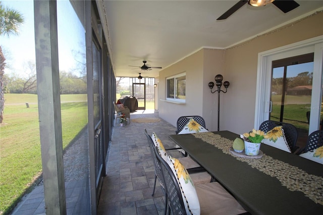 sunroom / solarium featuring a ceiling fan