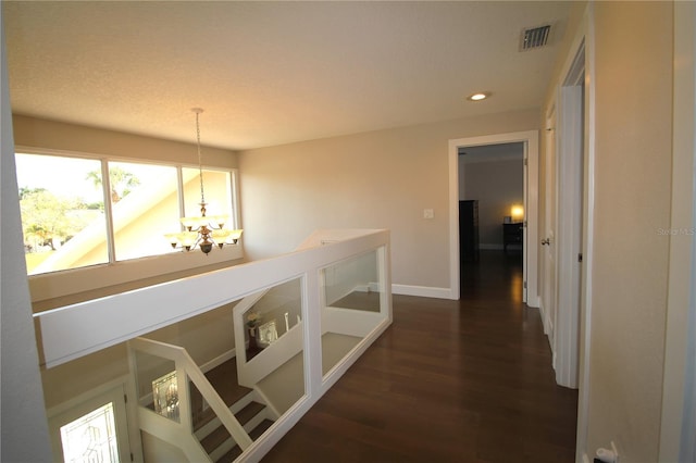 hall with baseboards, visible vents, dark wood-style floors, a chandelier, and recessed lighting