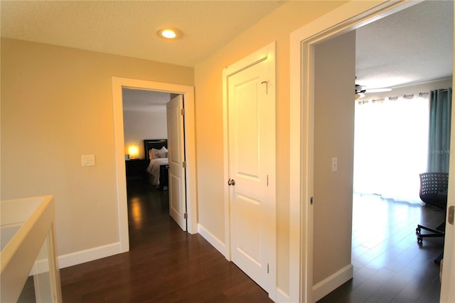 hallway with baseboards and dark wood finished floors